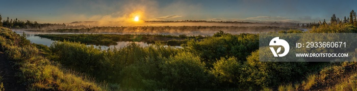 Sunrise over the Madison River just outside Yellowstone National Park with mirror like reflection from the water and steam fog, Baker’s Hole Campground, Montana