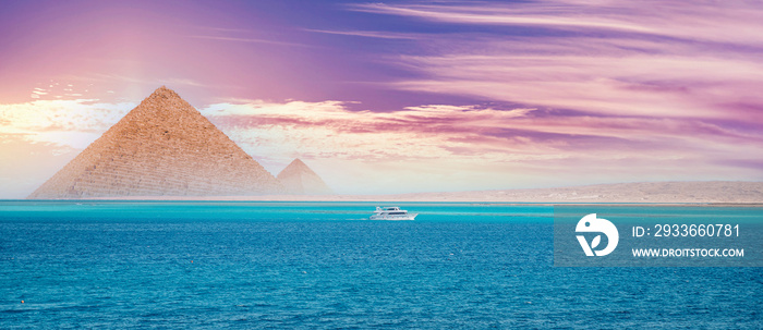 Sunset red sea with white yacht background egyptian pyramid Cairo, Egypt
