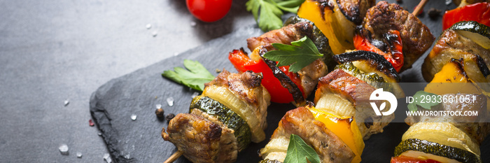 Grilled shish kebab with vegetables  on black.