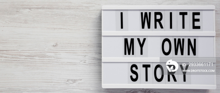 ’I write my own story’ words on a modern board on a white wooden background, top view. From above, overhead, flat lay. Copy space.