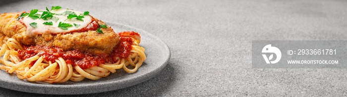 Chicken parmigiano with linguini pasta with copy space banner