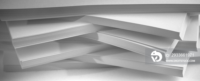 Several stacks of white paper on a white background