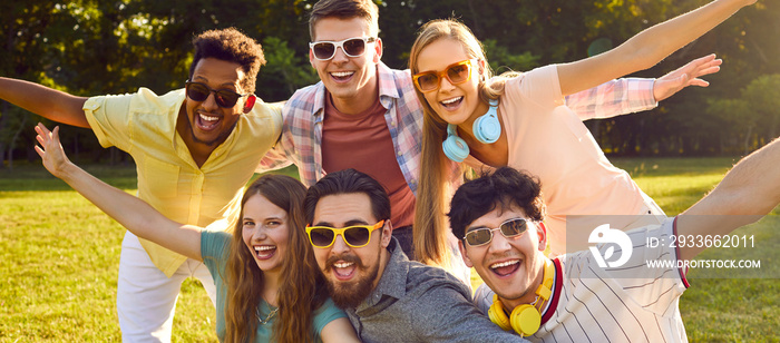 Portrait of happy, joyful, positive friends looking at the camera and smiling. Diverse group of young male and female friends enjoying summer, spending time outside and having fun together