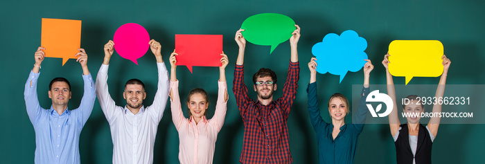 Group of six business people team standing together and holding colorful and different shapes of speech bubbles