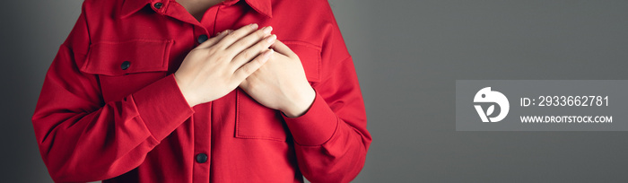 woman holds hands on her chest