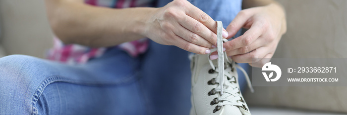 Woman tying shoelaces on new demi leather boots.