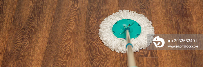 floor care, wet cleaning at home. washing brown floor with a round mop