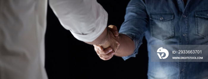 Casual businessmen making handshake during the meeting at night