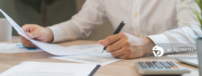 Close up hand of stress asian young employee business man, male calculate tax income and expenses, bills, credit card for payment or payday on table at home office. Financial, finance people concept.