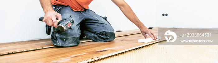 Handwerker verleget Parkett boden in einem modernen neubau Haus