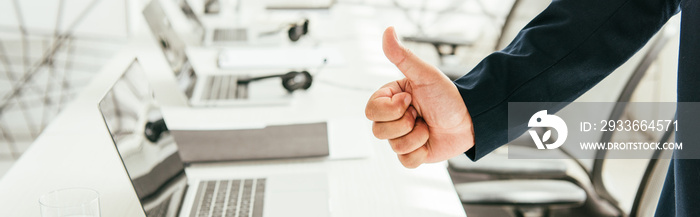 panoramic shot of broker showing thumb up in modern office