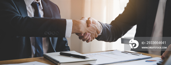 hand of client and banker shaking hands  on the meeting table after business investment budget done