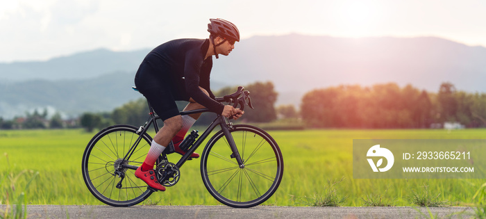 professional cyclist in cycling training suit against green nature blur background Healthy fitness and lifestyle concepts