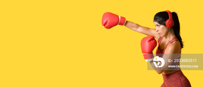 Sporty female boxer on yellow background with space for text