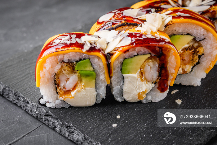 delicious sushi rolls on a black stone background