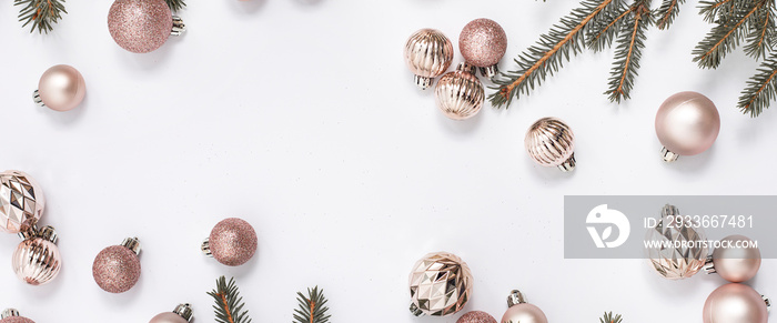 Decorative gold balls and sprigs of spruce on a white background. Top view, flat lay. Banner.