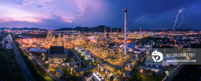 twilight cityscape panorama Oil and GAS refinery industry factory zone and storage tank with container train railroad tracks at night scene blue sky and cloud storm background