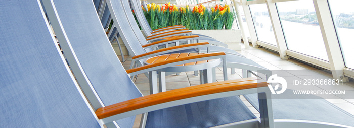 Sun loungers and deck chairs on deck around pool on modern cruiseship or cruise ship liner