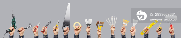 repair, construction and building equipment concept - close up of builder’s hands holding different working tools over grey background