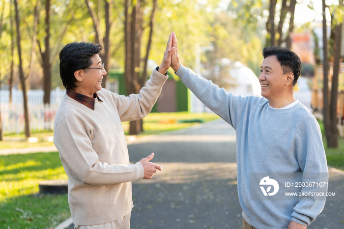 两个中老年男人开心地击掌