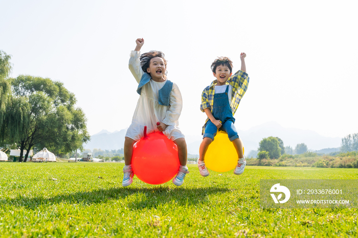 两个小孩在草地上做游戏