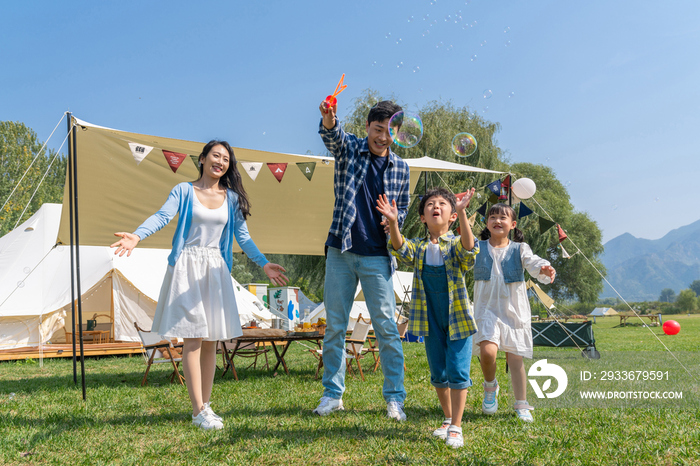 一家人在露营地天幕下玩耍