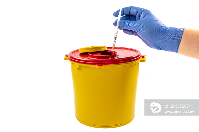 A person throwing away a syringe into a medical waste container.