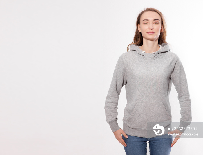 Shirt design and fashion concept - young woman in gray sweatshirt, gray hoodies, blank isolated on w