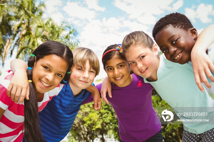 Happy children forming huddle at park