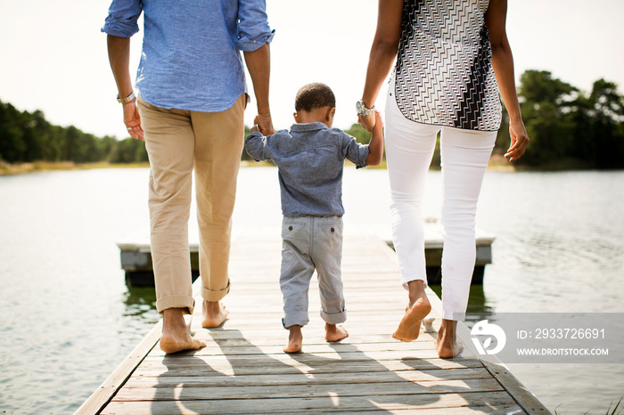 Rear view of boy with his parents walking on pier