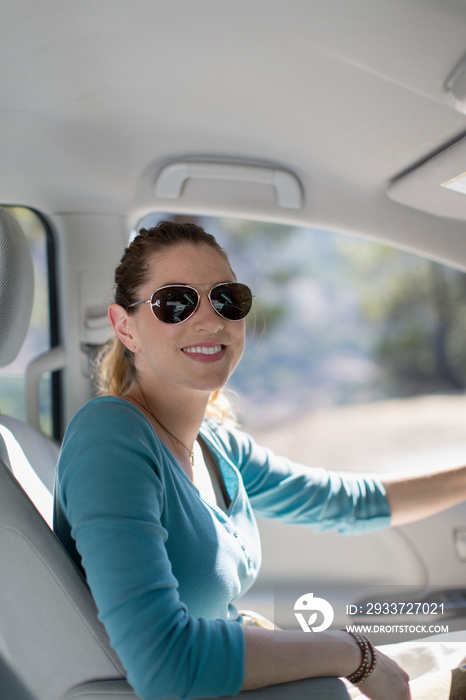 Portrait happy woman in sunglasses driving car