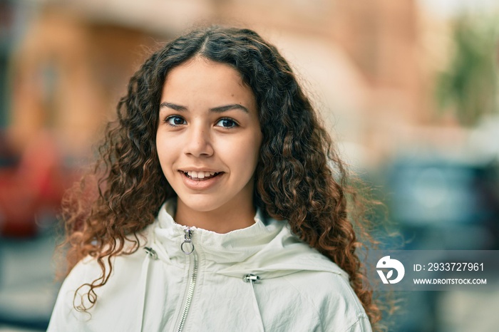 Hispanic teenager girl smiling happy standing at the city.