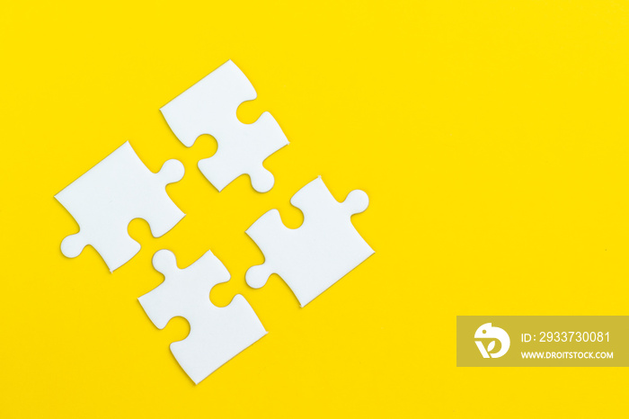 4 jigsaw puzzle on solid yellow background using as four important thing combine or working together