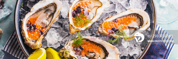 Oysters platter with lemon caviar and ice served on a Blue marine table.