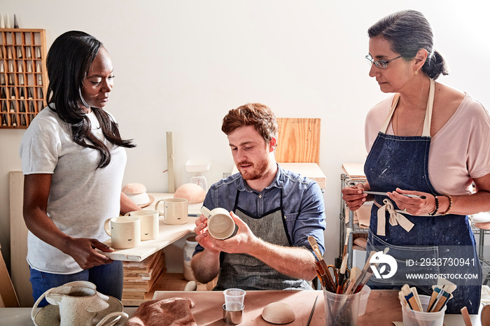 Group of people painting pottery in workshop