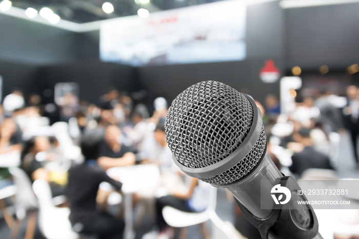 Microphone with blurred photo of conference hall or seminar room