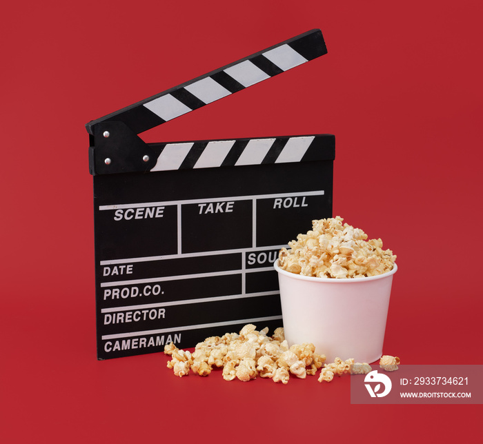 Clapper board with popcorn against red background,Cinema minimal concept
