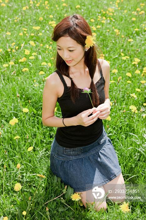 带着蒲公英在田野里的年轻女人