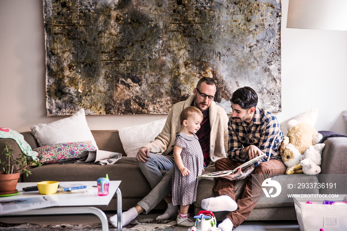 Fathers and daughter look at book