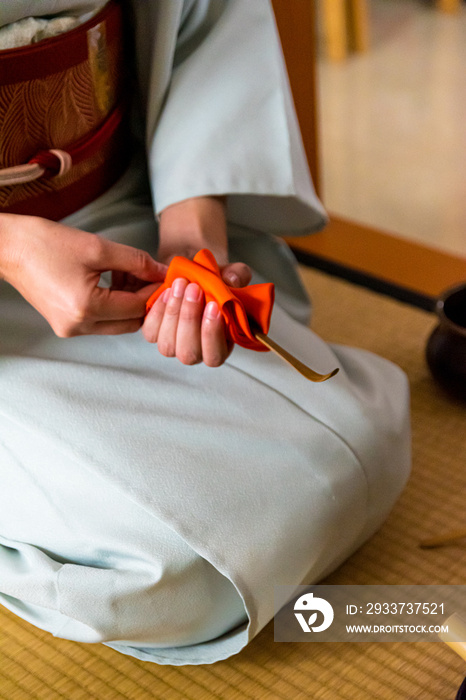 日本女人，茶艺大师，Sen Rikyu，用橙色的净化布清洁茶桶