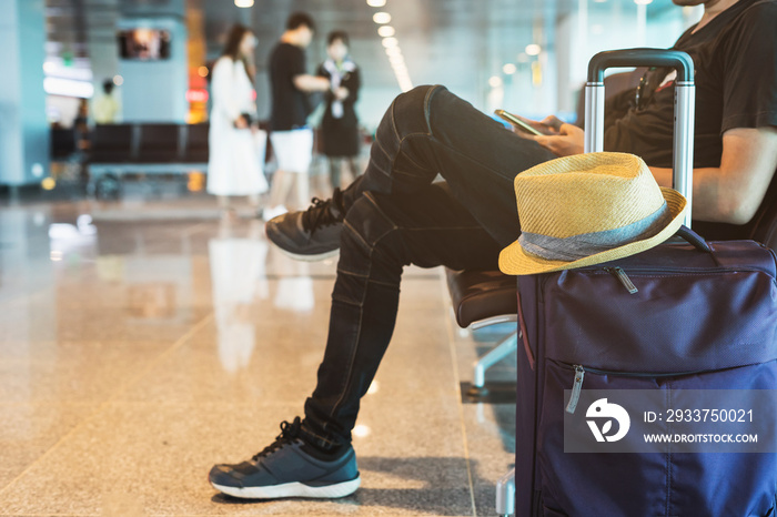年轻旅客在机场候机时使用智能手机