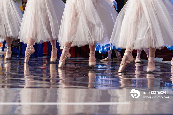 Ballet skirts and shoes reflect on the stage during a performance