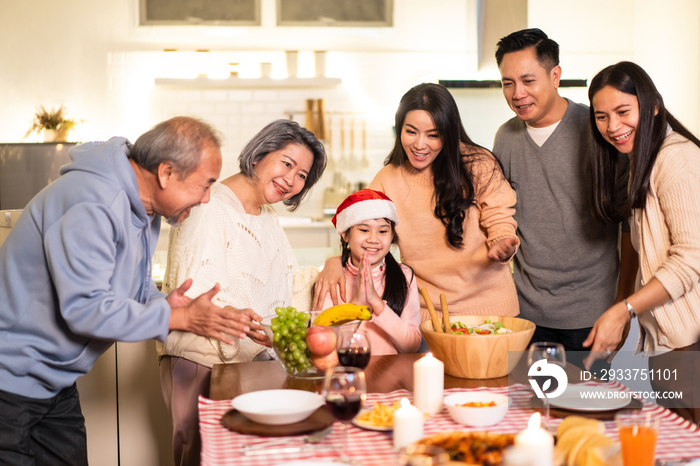 亚洲大家庭在为圣诞派对准备食物时唱歌