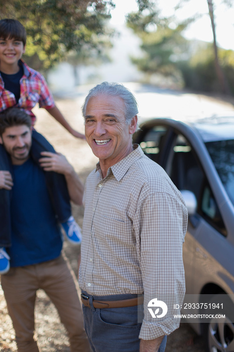 Portrait happy multi-generation family outside car