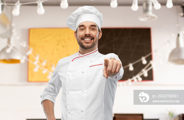 cooking, culinary and people concept - happy smiling male chef in toque pointing finger to camera ov