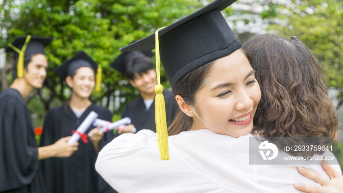 穿着毕业礼服、戴着毕业帽的女学生在祝贺仪式上拥抱家长。