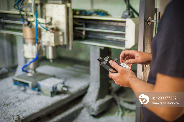 Engineer worker technician operating with CNC milling metal engraving machine in factory workshop.