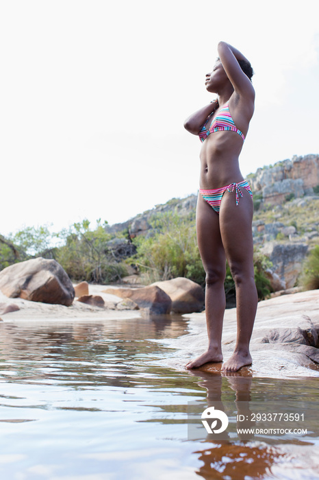 Young woman in bikini relaxing at lake