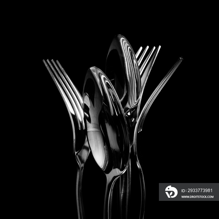 Abstract shapes with flatware on black background