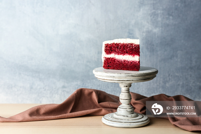 Slice of delicious red velvet cake on wooden stand